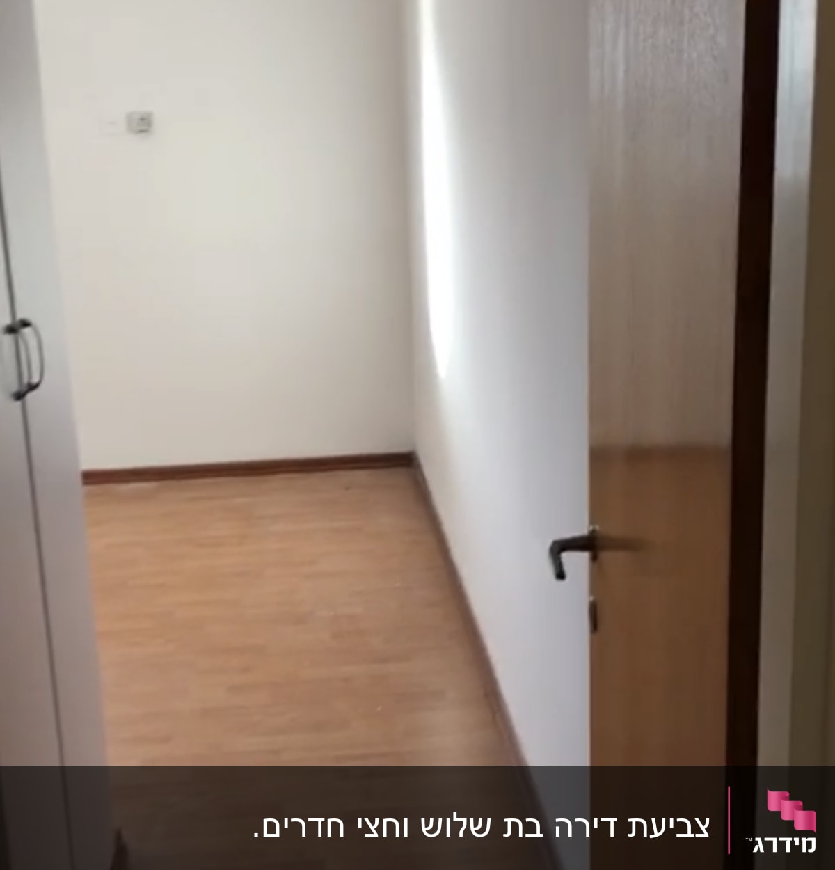 חדר ריק עם קירות לבנים ורצפת עץ
